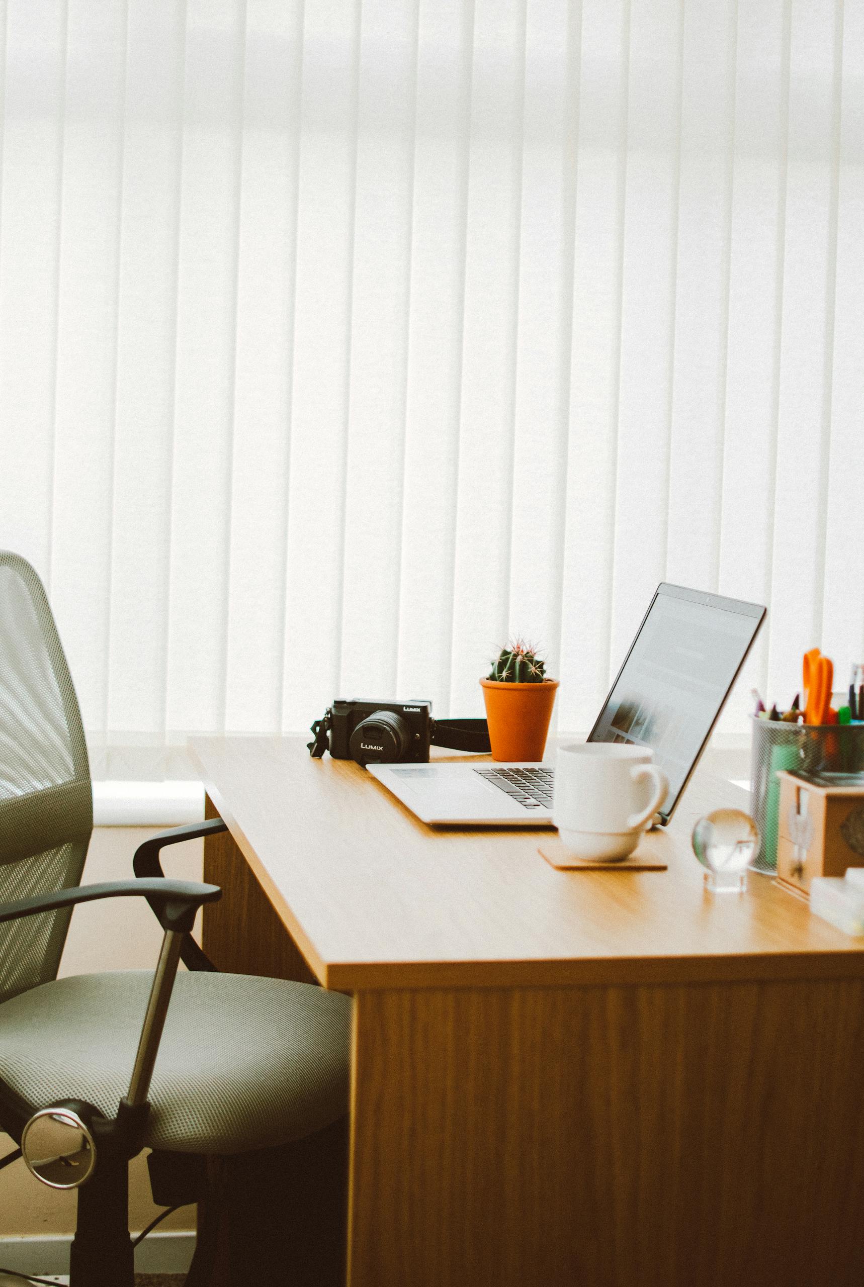 A clean and bright home office setup with a laptop, chair, and desk essentials.