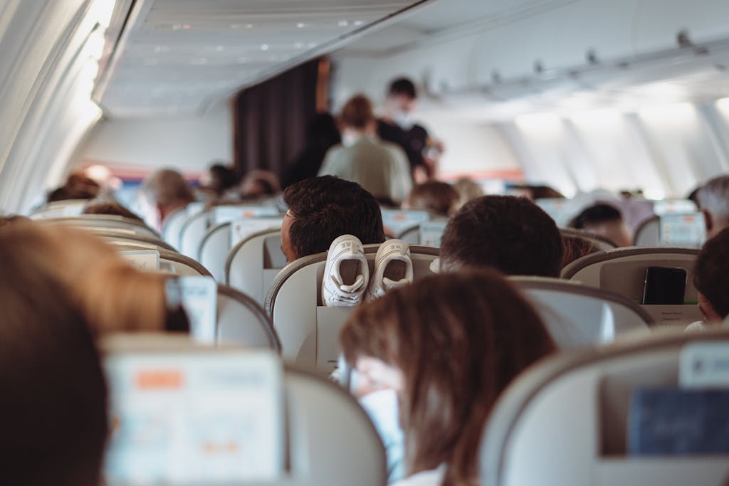 View of passengers wearing masks and seated in economy class during flight.